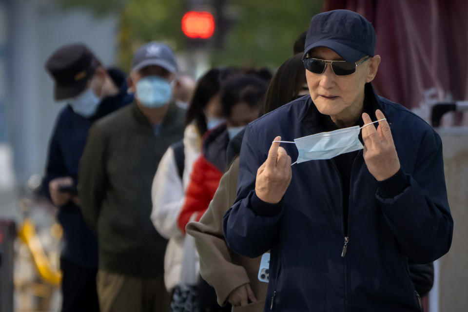 A man puts his face mask on after taking a COVID-19 test at a coronavirus testing site in Beijing, Tuesday, Nov. 1, 2022. Shanghai Disneyland was closed and visitors temporarily kept in the park for virus testing, the city government announced, while social media posts said some amusements kept operating for guests who were blocked from leaving. (AP Photo/Mark Schiefelbein)