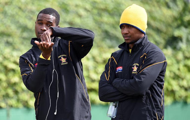 Zimbabwe captain Elton Chigumbura (L) gestures as teammate Regis Chakabva looks on during a training session at the Bellerive Oval ground ahead of the 2015 Cricket World Cup Pool B match between Ireland and Zimbabwe on March 6, 2015