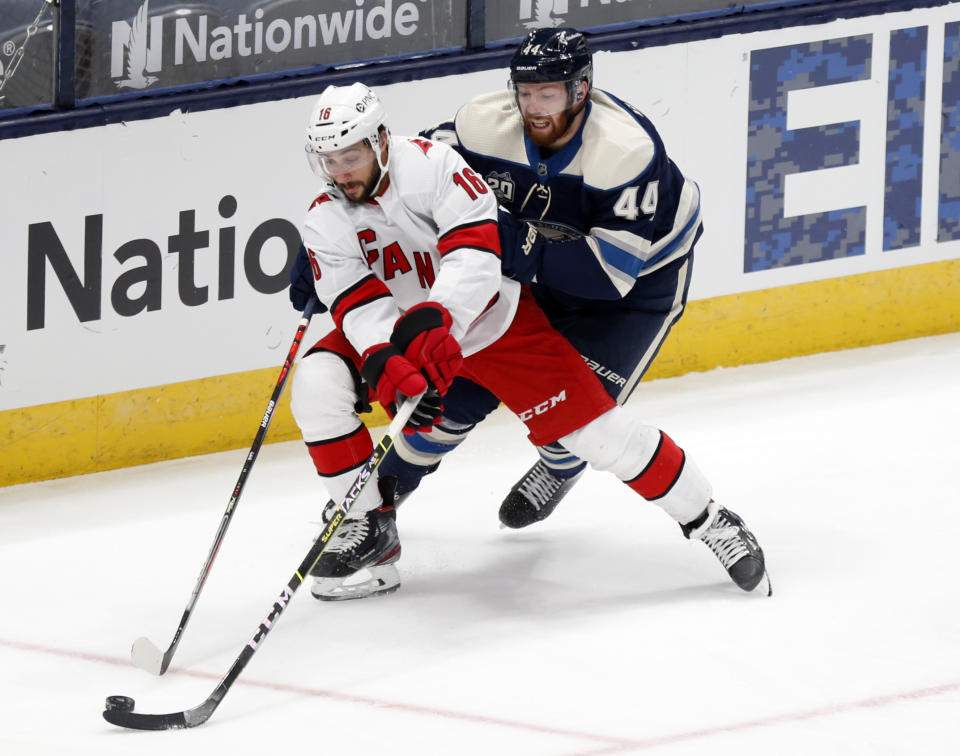 Carolina Hurricanes forward Vincent Trocheck, left, controls the puck against Columbus Blue Jackets defenseman Vladislav Gavrikov during the second period of an NHL hockey game in Columbus, Ohio, Sunday, Feb. 7, 2021. (AP Photo/Paul Vernon)