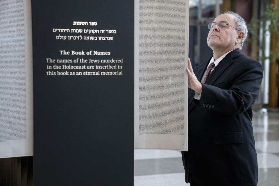 Dani Dayan, Chairman of Yad Vashem, browses the pages of the Yad Vashem Book of Names of Holocaust Victims Exhibit before the arrival of Antonio Guterres, United Nations Secretary General, Thursday, Jan. 26, 2023, at United Nations headquarters. (AP Photo/John Minchillo)