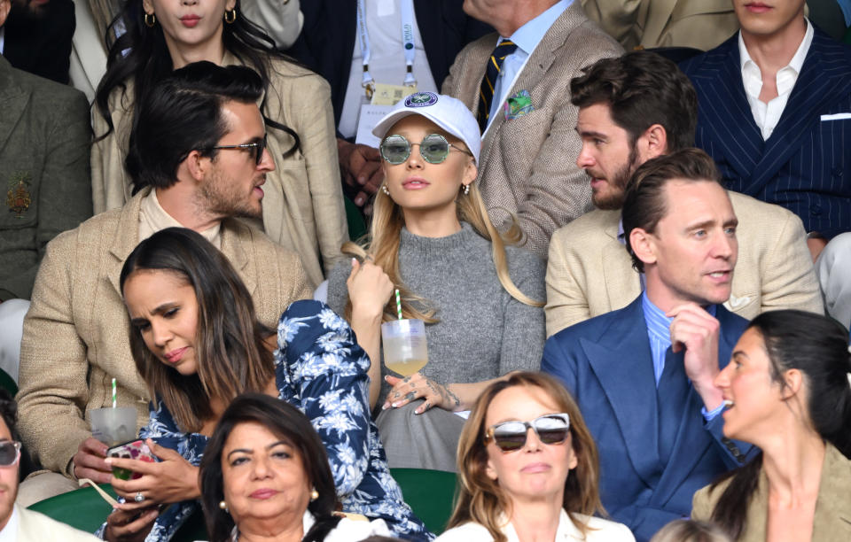 Ariana Grande sits next to actors Jonathan Bailey (left) and Andrew Garfield (right) without her Dalton Gomez wedding ring.