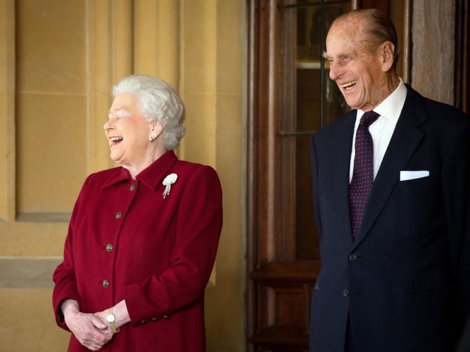 Queen Elizabeth and Prince Philip laugh in 2014.