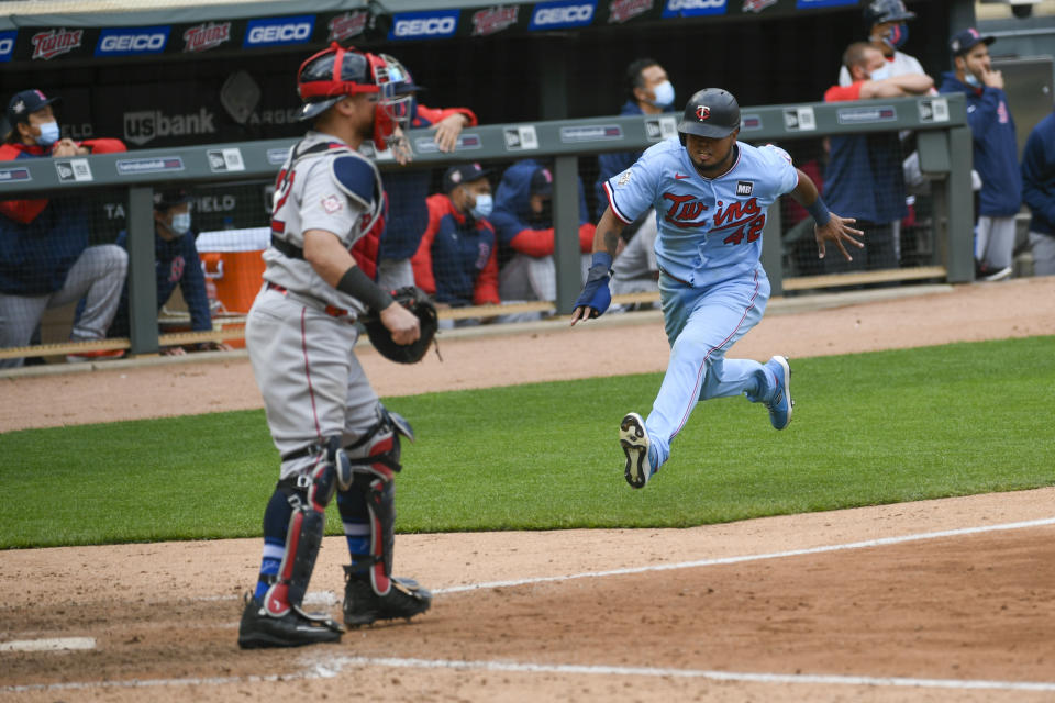 Minnesota Twins' Jorge Polanco, right, races home to scores the winning run on a single by Max Kepler as Boston Red Sox catcher Christian Vazquez waits for the throw in the ninth inning of a baseball game, Thursday, April 15, 2021, in Minneapolis. The Twins won 4-3. (AP Photo/Craig Lassig)