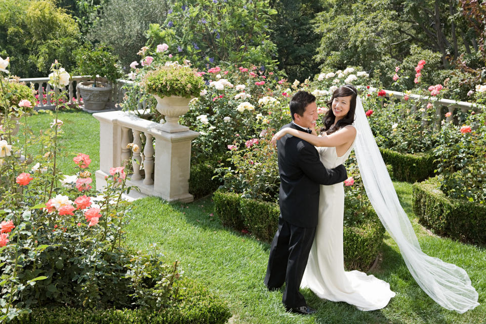 A bride and groom embracing in a garden