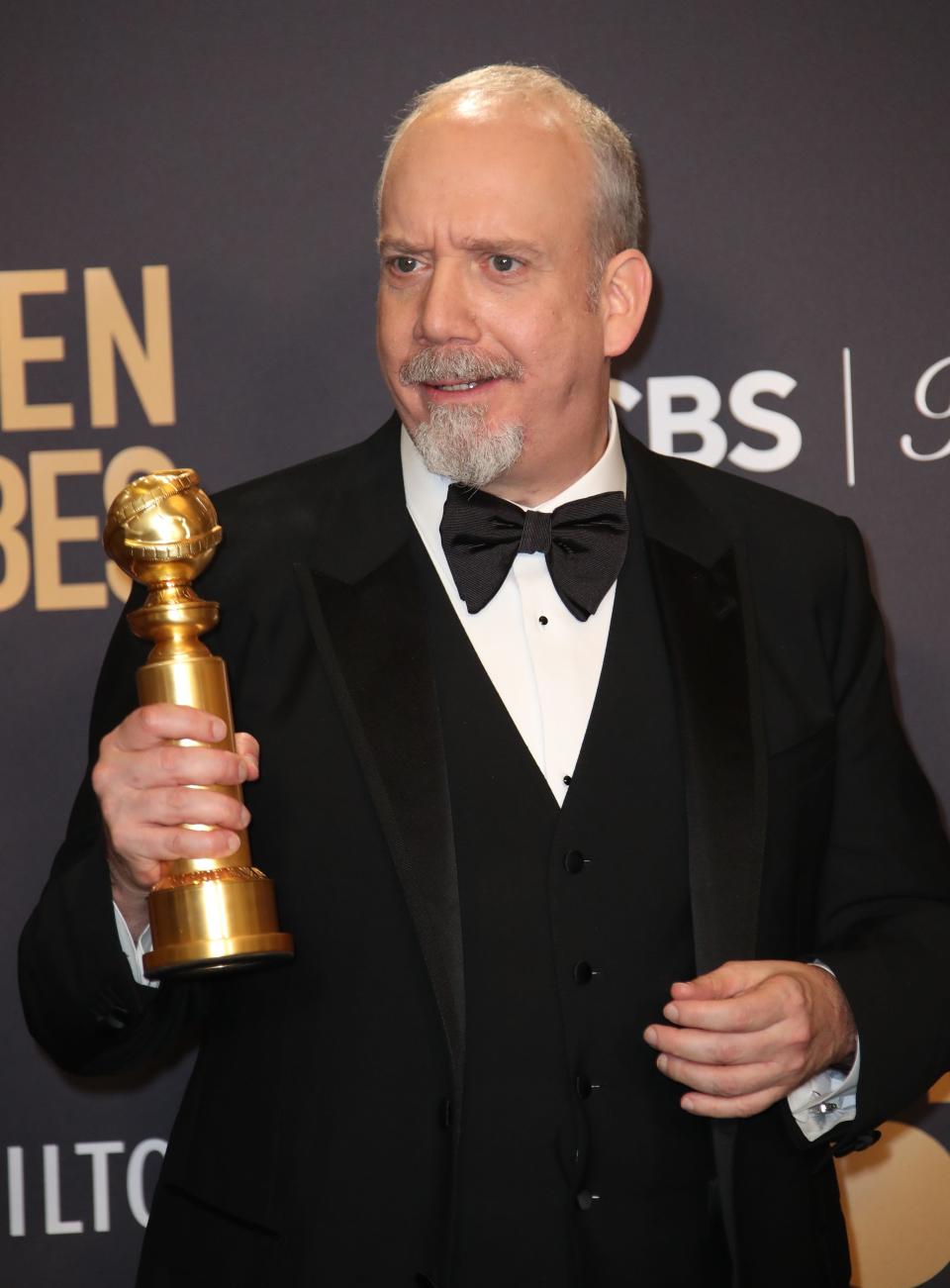 "The Holdovers" star Paul Giamatti poses in the press room with his Globe Globe for best actor in a comedy.