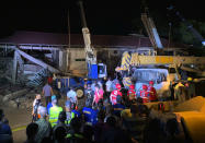 Workers continue rescue efforts on people still trapped inside a collapsed building at Porac town, Pampanga province, northern Philippines Monday, April 22, 2019. A strong 6.1 magnitude earthquake in the north Philippines on Monday trapped some people in a collapsed building, damaged an airport terminal and knocked out power in at least one province, officials said. (AP Photo/Bullit Marquez)