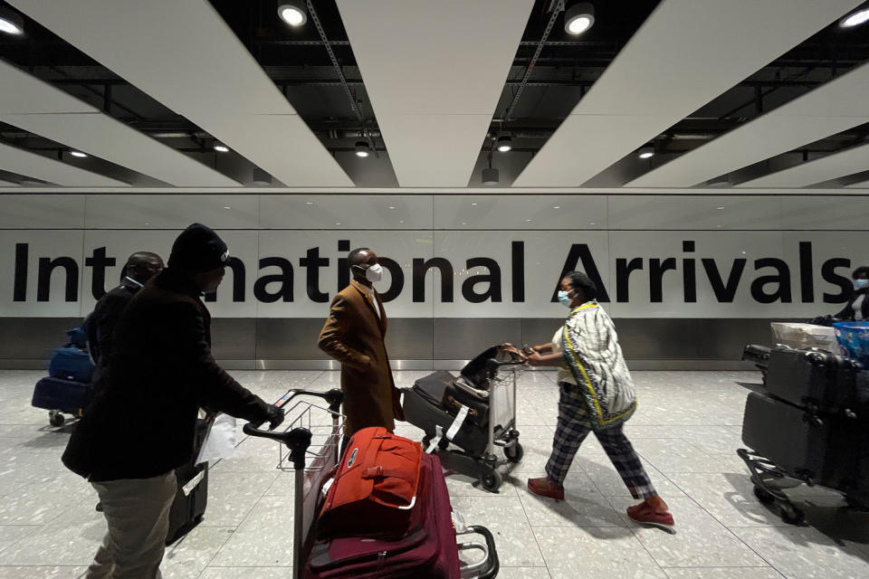  International passengers walk through the arrivals area at Terminal 5 at Heathrow Airport on November 26, 2021 in London, England.