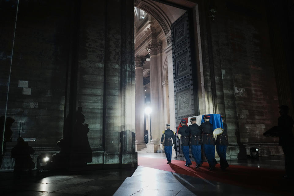 Six carriers of the Air Force and Space carry the cenotaph of Josephine Baker, covered with the French flag, into the Pantheon in Paris, France, Tuesday, Nov. 30, 2021, where she is to symbolically be inducted, becoming the first Black woman to receive France's highest honor. Her body will stay in Monaco at the request of her family. (Thibault Camus/Pool Photo via AP)