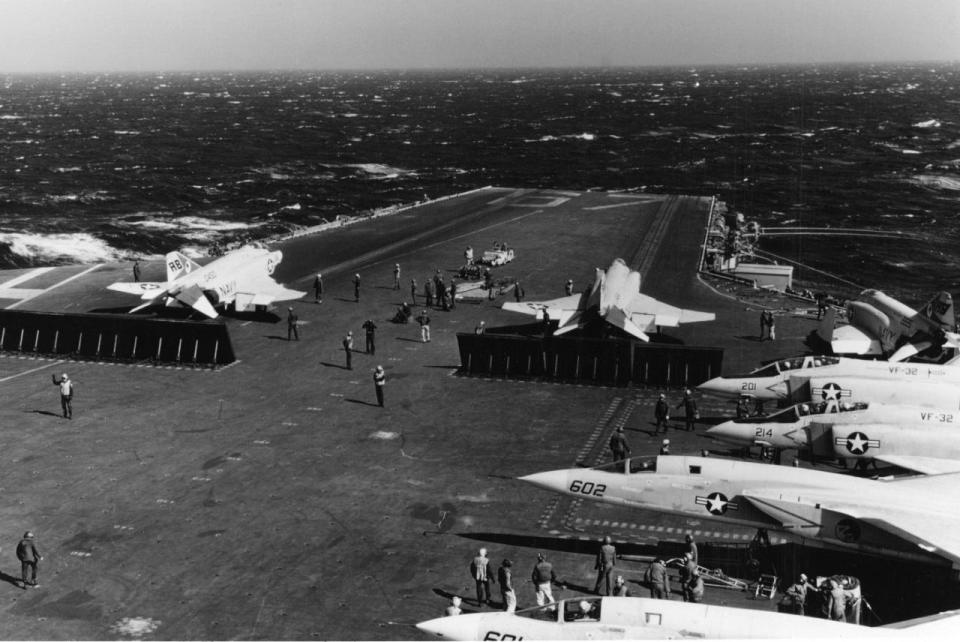 Two F-4 Phantom II fighter aircraft are being readied for launch from the flight deck of USS John F. Kennedy in the Mediterranean Sea.