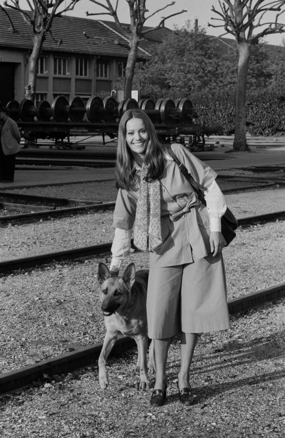 Claudine Auger poses with a dog