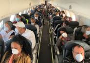 People wear protective masks in response to the spreading of coronavirus (COVID-19), during a flight between Caracas Venezuela and la Havana, Cuba