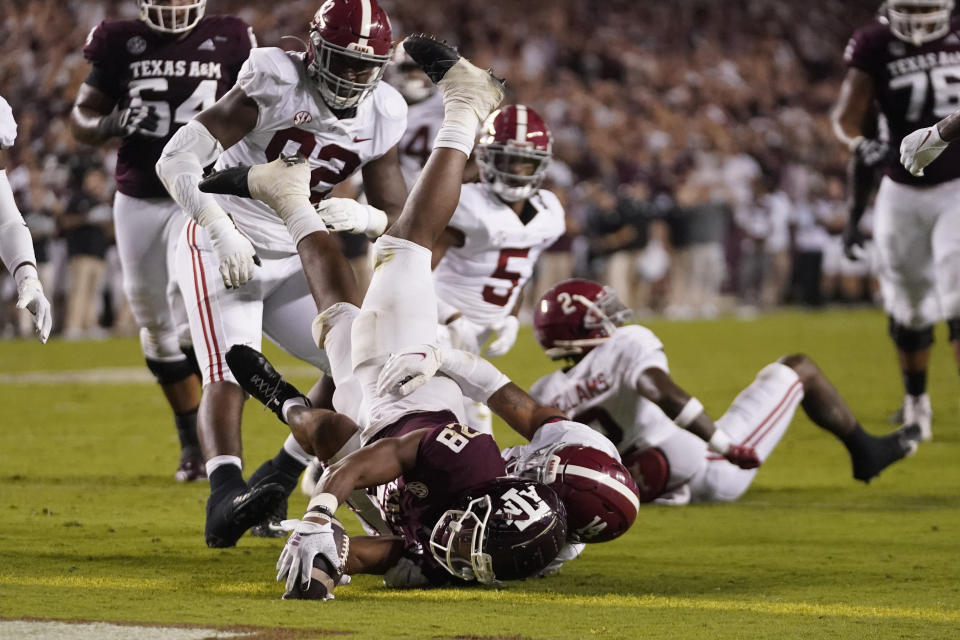 Texas A&M running back Isaiah Spiller (28) dives over the goal line for a touchdown as Alabama defensive back Brian Branch (14) defends during the first half of an NCAA college football game Saturday, Oct. 9, 2021, in College Station, Texas. (AP Photo/Sam Craft)