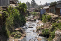 A tributary full of garbage, which feeds into the Nairobi River, flows through the informal settlement of Kibera in Nairobi, Kenya, Wednesday, Jan. 11, 2023. As clean water runs short, one of Africa's fastest growing cities is struggling to balance the needs of creating jobs and protecting the environment, and the population of over 4 million feels the strain. (AP Photo/Khalil Senosi)