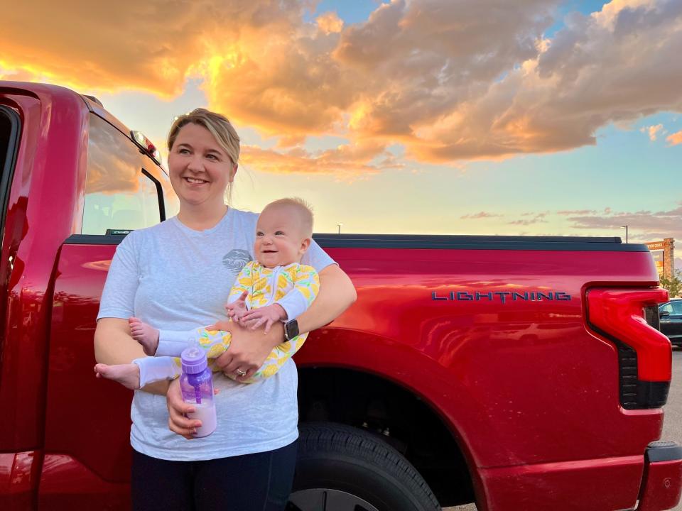 Emily Jaehnert holds her daughter, MacKenzie, while their Ford F-150 Lightning  was charging. This is part of their road trip back from Wisconsin to Richland, Washington in September 2022.