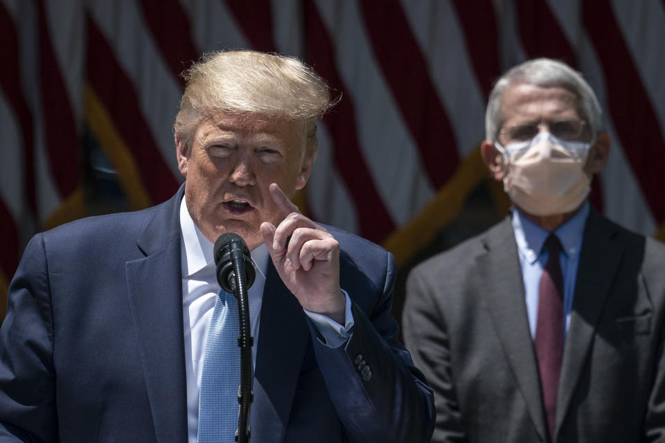 Dr. Anthony Fauci (R), director of the National Institute of Allergy and Infectious Diseases, looks on as U.S. President Donald Trump delivers remarks about coronavirus vaccine development in the Rose Garden of the White House on May 15, 2020 in Washington, DC.(Drew Angerer/Getty Images)