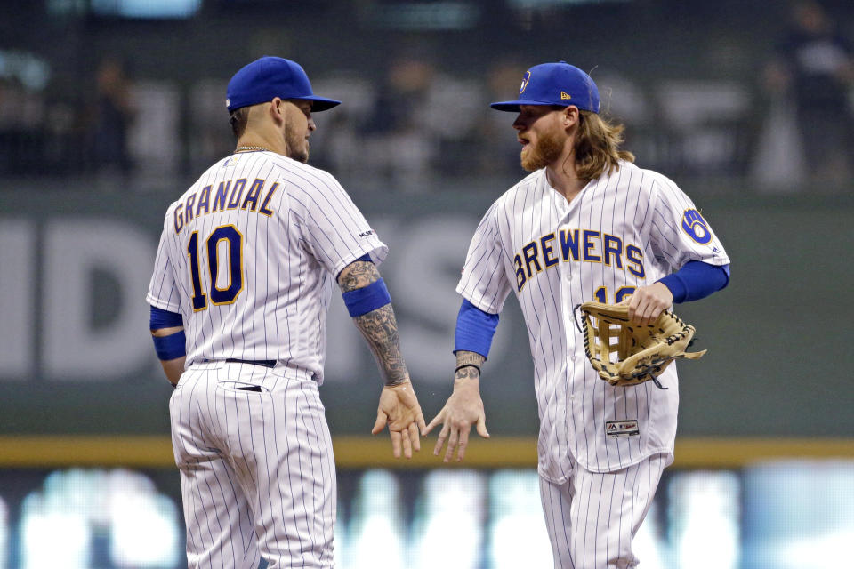 Milwaukee Brewers' Ben Gamel, right, and Yasmani Grandal congratulate one another after the team's baseball game against the Pittsburgh Pirates on Friday, Sept. 20, 2019, in Milwaukee. The Brewers won 10-1. (AP Photo/Aaron Gash)