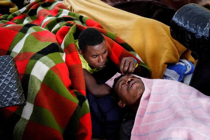 Migrants rest on board of NGO Proactiva Open Arms rescue boat in central Mediterranean Sea