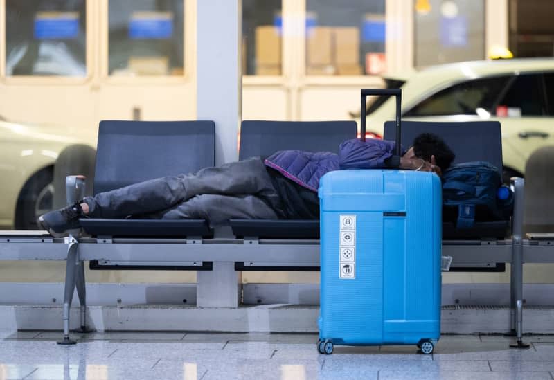 A man sleeps on a bench at Frankfurt Airport. The trade union Verdi has once again called on Lufthansa ground staff to go on a warning strike. Boris Roessler/dpa