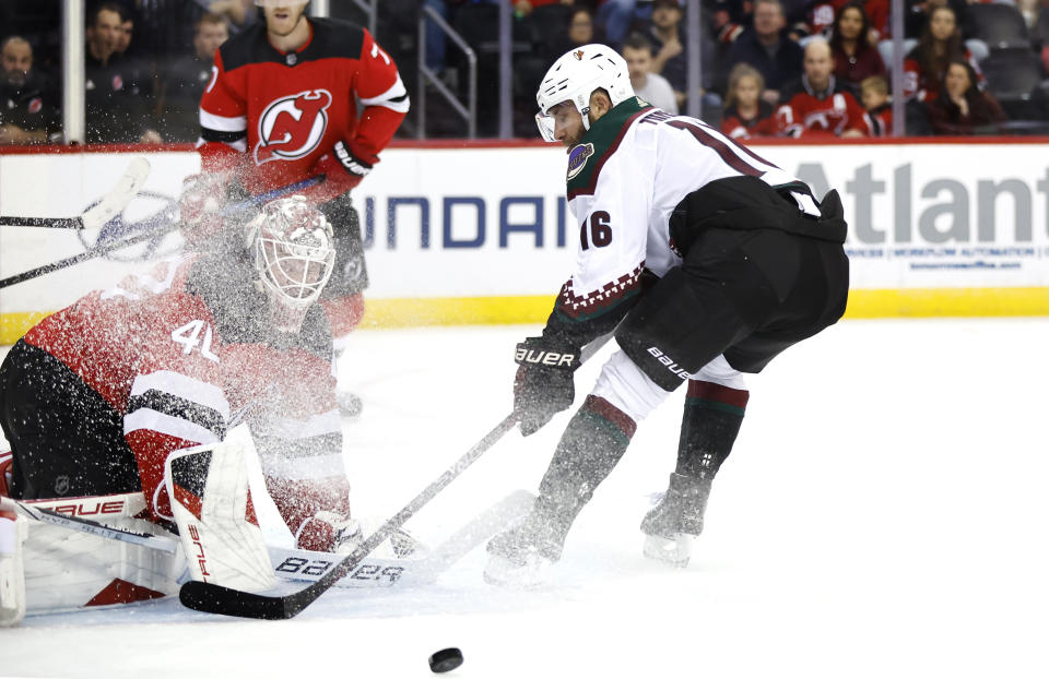 New Jersey Devils goaltender Akira Schmid (40) makes a save against Arizona Coyotes left wing Jason Zucker (16) during the first period of an NHL hockey game Friday, Oct. 13, 2023, in Newark, N.J. (AP Photo/Noah K. Murray)