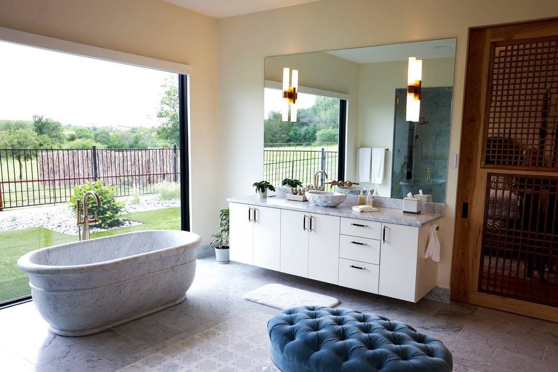 The master bath features a custom-built bathtub and a large window that provides natural light. Lazy H Ranch is a 50-acre property in Fort Worth. The main home has 5 bedrooms and 6.5 bathrooms as well as an infinity-edge pool. There is also an eight-stall stable, two guest houses and a ranch-hand house.