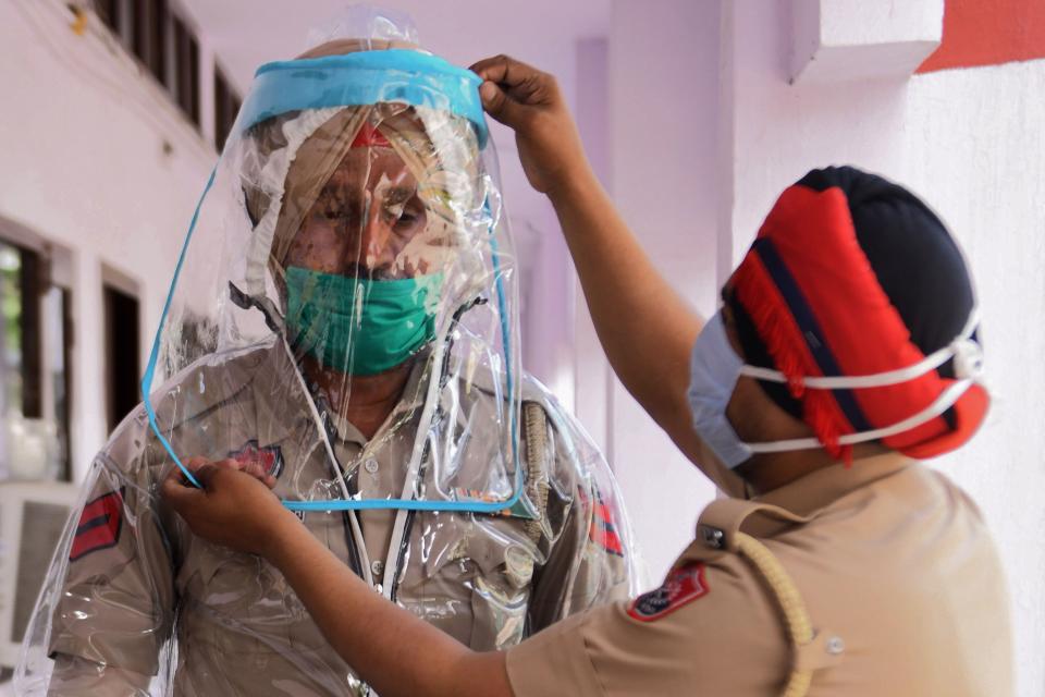 Police personnel in India try on personal protective equipment during a government-imposed nationwide lockdown as a preventive measure against the coronavirus.