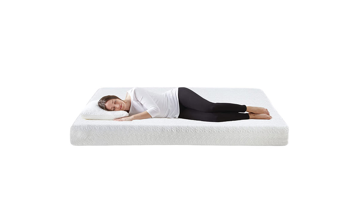 Woman laying on her side on bare mattress