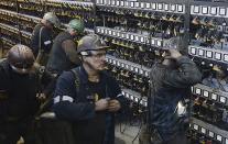 FILE - In this Nov. 21, 2018, file photo, miners put away their equipment after an underground shift at the Wujek coal mine in Katowice, in Poland's southern mining region of Silesia. The coronavirus has ripped through Poland's coal mines, where men descend deep underground in tightly packed elevators and work shoulder-to-shoulder. The virus hot spots, centered in the southern Silesia region, have paralyzed an already-troubled industry, forcing many to stay home from work and triggering a three-week closure of many state-run mines. (AP Photo/Czarek Sokolowski, File)