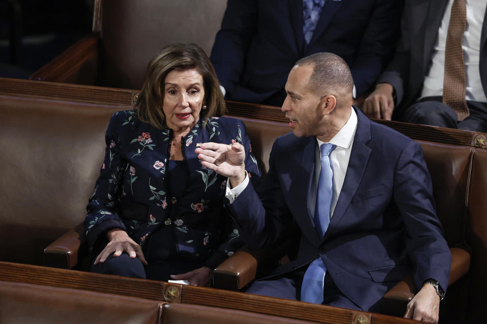 Democratic Leader Hakeem Jeffries and Rep. Nancy Pelosi speak to one another in their seats in the House.