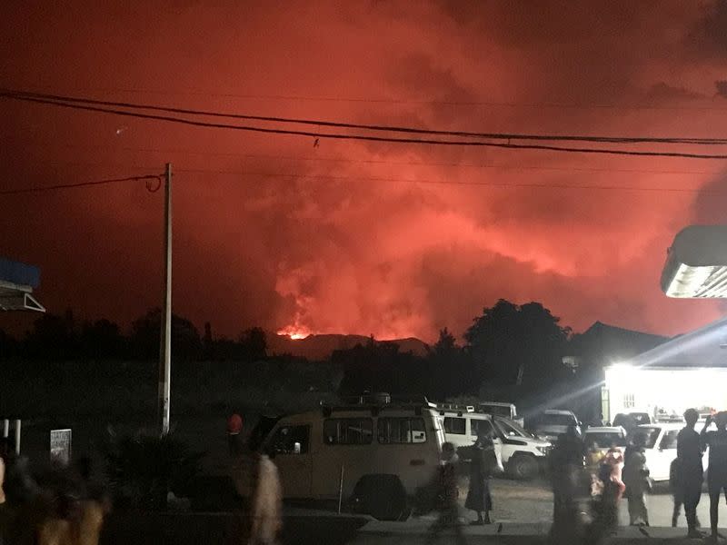 A general view shows civilians watching the smoke and flames of the volcanic eruption near Goma