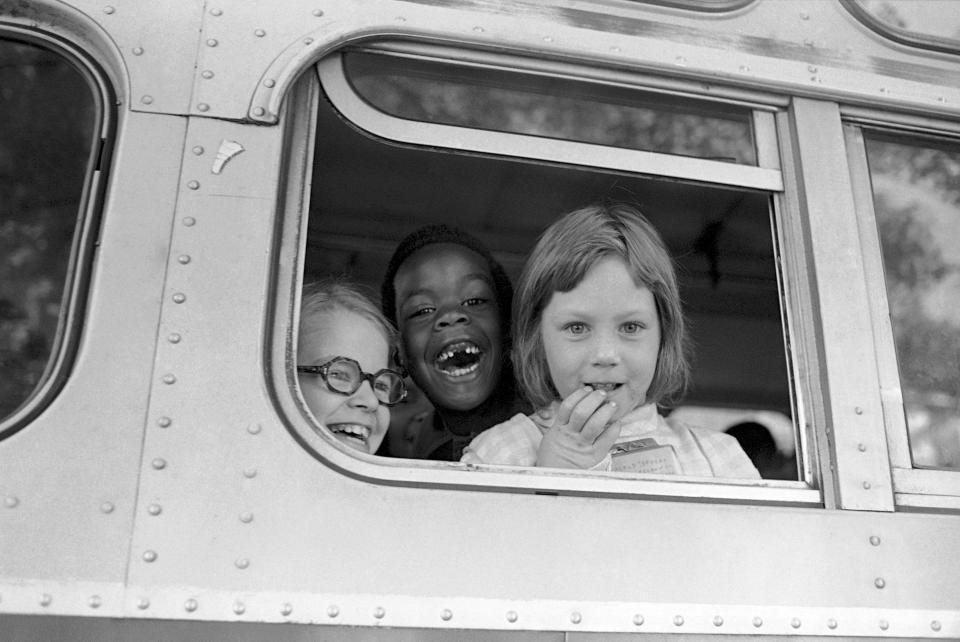 FILE - Children smile from window of a school bus in Springfield, Mass., as court-ordered busing brought Black children and white children together in elementary grades without incident, Sept. 16, 1974. Friday, May 17, 2024, marks 70 years since the U.S. Supreme Court ruled that separating children in schools by race was unconstitutional. On paper, Brown v. Board of Education still stands. In reality, school integration is all but gone, the victim of a gradual series of court cases that slowly eroded it, leaving little behind. (AP Photo/Peter Bregg, File)