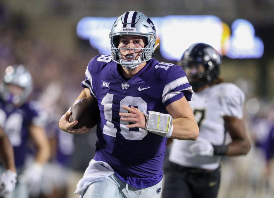 Sep 23, 2023; Manhattan, Kansas, USA; Kansas State Wildcats quarterback Will Howard (18) runs away from several UCF Knights defenders to score a touchdown late in the fourth quarter at Bill Snyder Family Football Stadium. Mandatory Credit: Scott Sewell-USA TODAY Sports