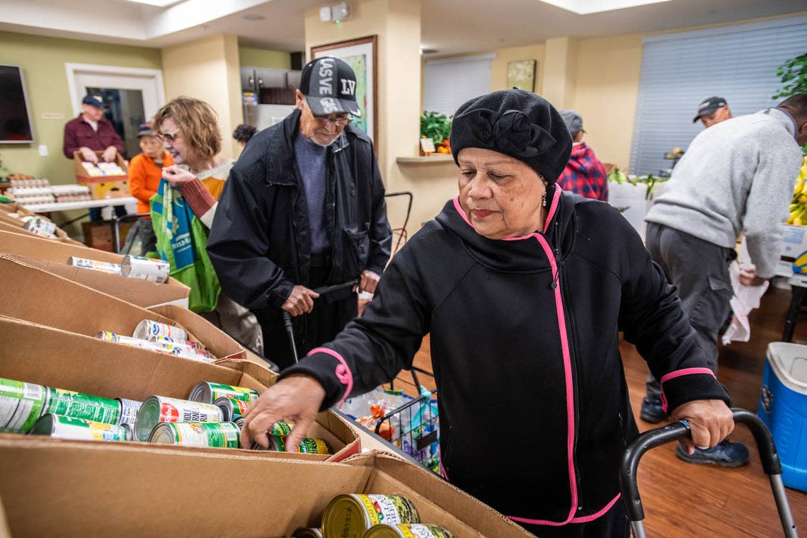 Arbor Creek Family Apartments resident Miriam Cruz gathers groceries donated by the Elk Grove Food Bank Services on Nov. 21. The organization asks Book of Dreams readers for donations to resume their mobile cooking classes for seniors.