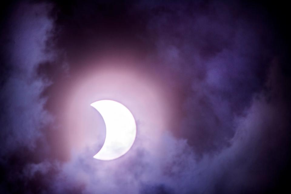 Heavy clouds drift across the 2017 solar eclipse over Peoria, Ill. "The forecast for Eclipse Day continues to be cloudy, however, not all hope is lost!" the Dallas-Fort Worth National Weather Service office says of next Monday's solar eclipse. "There is a medium chance of partial visibility across parts of North and Central Texas."