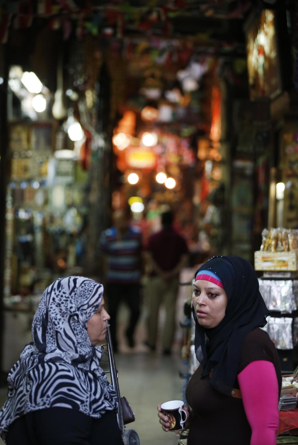 Egyptian vendors talk in the Khan El-Khalili market, normally a popular tourist destination, in Cairo, Egypt, Monday, Sept. 9, 2013. Before the 2011 revolution that started Egypt's political roller coaster, sites like the pyramids were often overcrowded with visitors and vendors, but after a summer of coup, protests and massacres, most tourist attractions are virtually deserted to the point of being serene. (AP Photo/Lefteris Pitarakis)