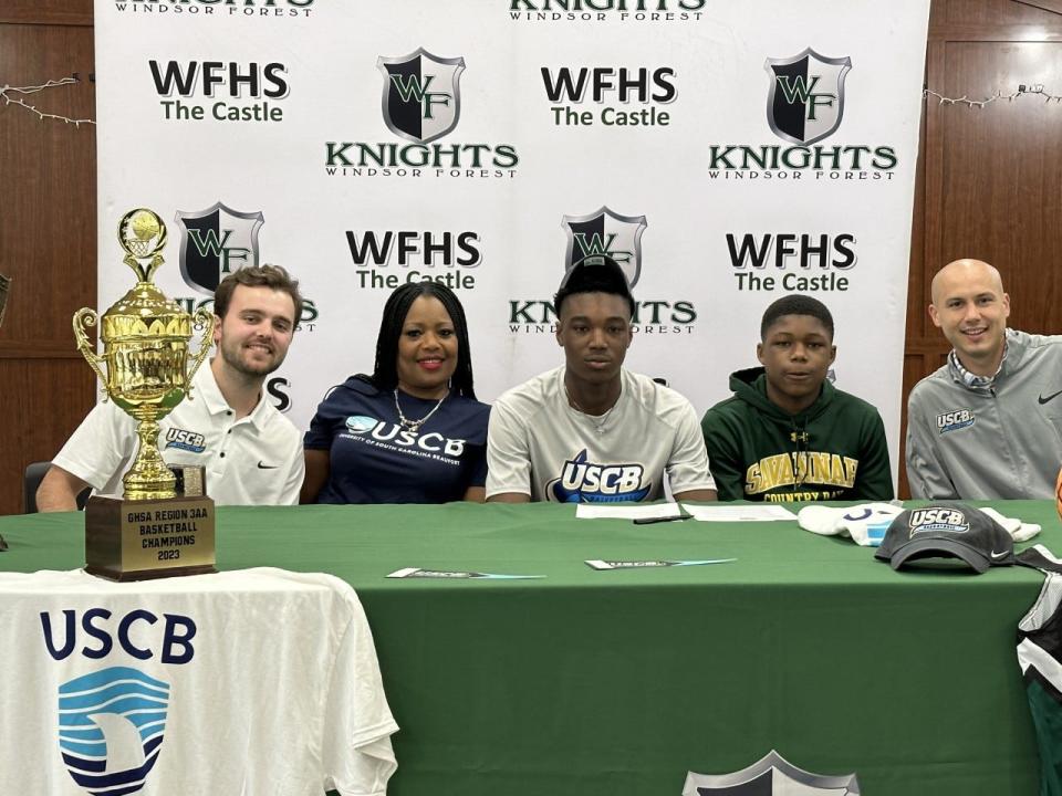 Qurahn Anderson of Windsor Forest with family and USCB basketball coaches after he signed with USC Beaufort.