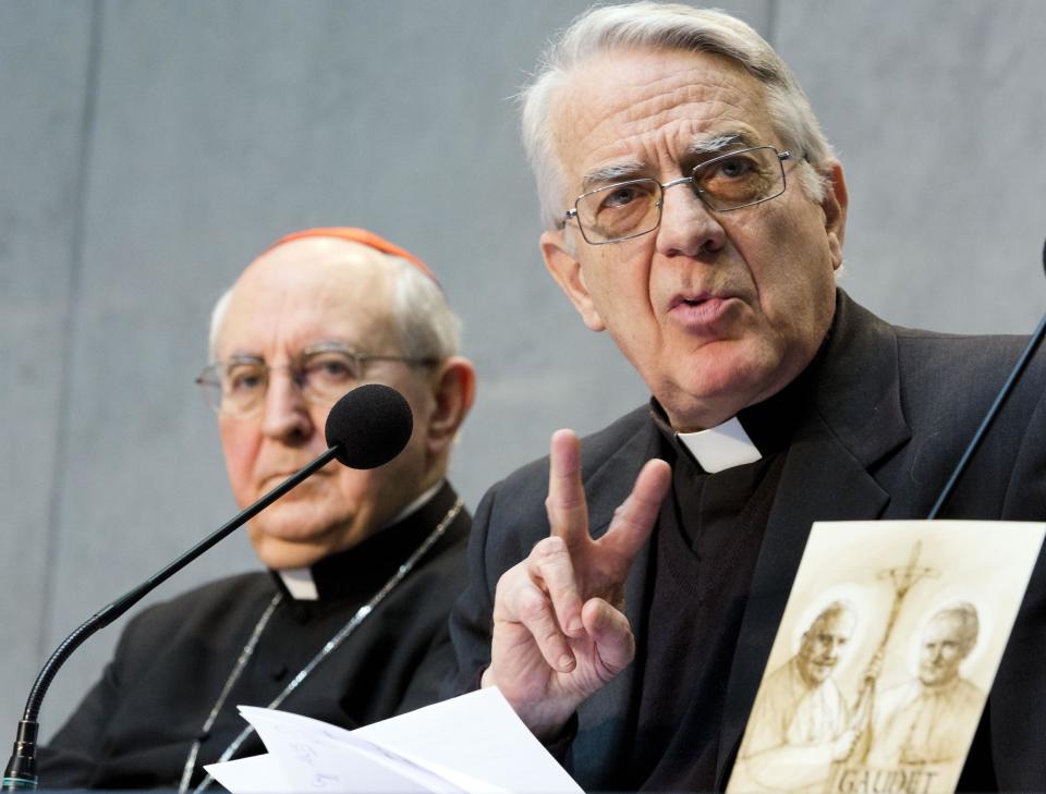 Director of the Holy See press room Father Federico Lombardi, right, flanked by Cardinal Agostino Vallini, speaks during a press conference at the Vatican, Monday, March 31, 2014, on the canonisation of two late popes John XXIII, at left in the picture, and John Paul II, at right in the picture, who will be made saints on April 27, 2014. The simple, low-frills style of Pope Francis is having an effect on the upcoming canonizations of Popes John Paul II and John XXIII. Organizers of the event said Monday the April 27 saint-making ceremony will be a much more sober affair compared to the three-day extravaganza that accompanied John Paul's 2011 beatification. That 2011 event included a prayer vigil on Rome's Circus Maximus field for tens of thousands of people and ended up costing several times the original estimate of 1.2 million euros. (AP Photo/Domenico Stinellis)