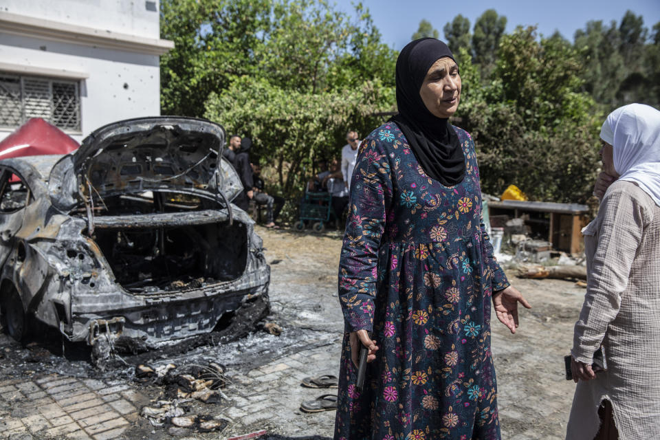 Relatives gather outside the damaged home of Nadine,16, and Khalil Awaad, a father and daughter who were killed by a rocket fired from the Gaza Strip, in their village of Dahmash near the Israeli city of Lod, Wednesday, May 12, 2021. (AP Photos/Heidi Levine)