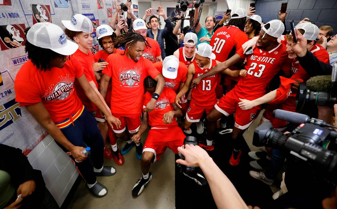 N.C. State players celebrate after putting their sticker on the wall after the Wolfpack’s 84-76 victory over UNC in the championship game of the 2024 ACC Men’s Basketball Tournament at Capital One Arena in Washington, D.C., Saturday, March 16, 2024.