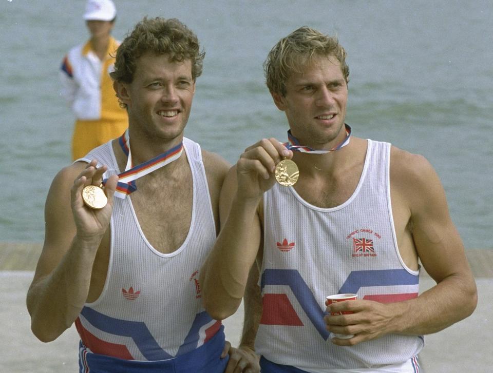 FILE - British rowing pairs teammates Andrew Holmes, left, and Steven Redgrave, show off their gold medals for the event at the Seoul Summer Olympics Saturday, September 24, 1988. (AP Photo/Rudi Blaha, File)