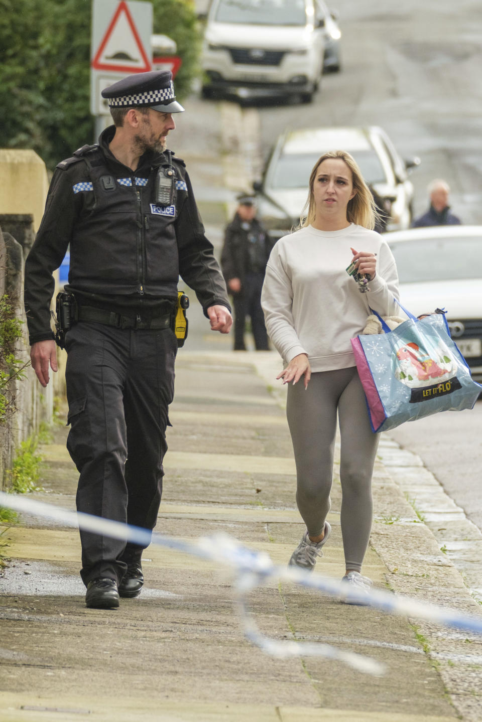 A police officer speaks to a member of the public after homes were evacuated when a suspected Second World War explosive device was discovered in a garden on St Michael Avenue in Plymouth, England, Thursday Feb. 22, 2024. (Matt Keeble/PA via AP)