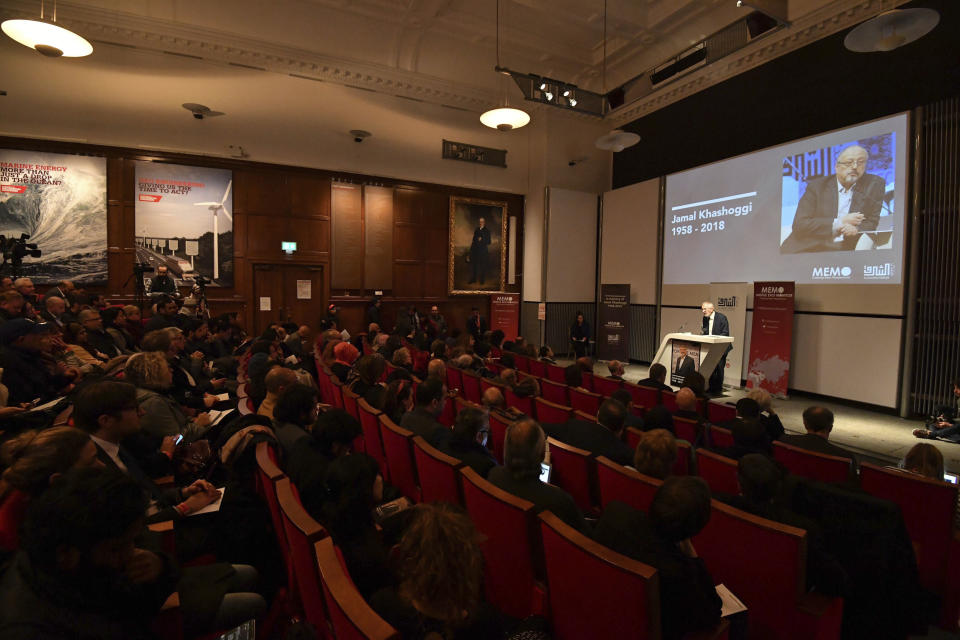 People attend a memorial event for killed Saudi journalist Jamal Khashoggi, seen on screen, at the Mechanical Engineers Institute in London, Monday Oct. 29, 2018. The Al Sharq Forum think tank and Middle East Monitor have organised the event in honour of the murdered journalist Khashoggi who died in the Saudi consulate in Turkey. (John Stillwell/PA via AP)