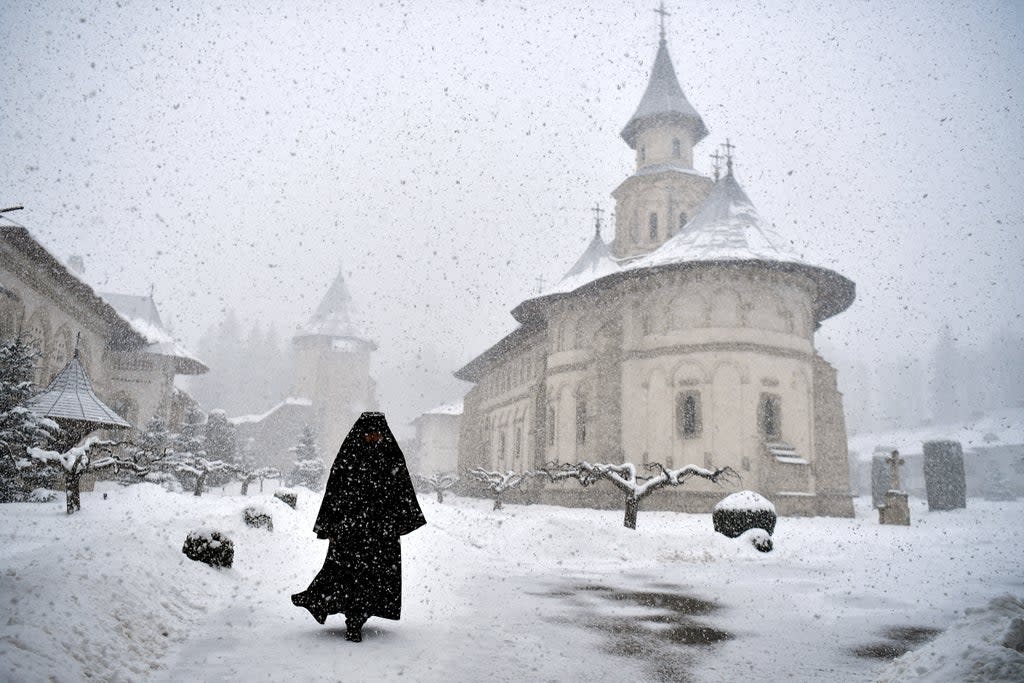 Romanian Orthodox monk Father Mikhail departs after mass at the church in Putna monastery, Romania (Reuters)