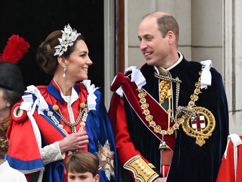 Kate Middleton and Prince William look at each other on the balcony of Buckingham Palace after the coronation of King Charles