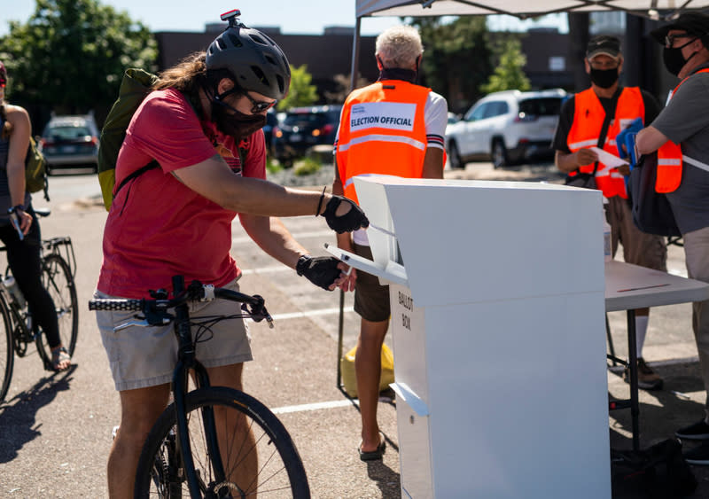 Voter puts ballot into mailbox