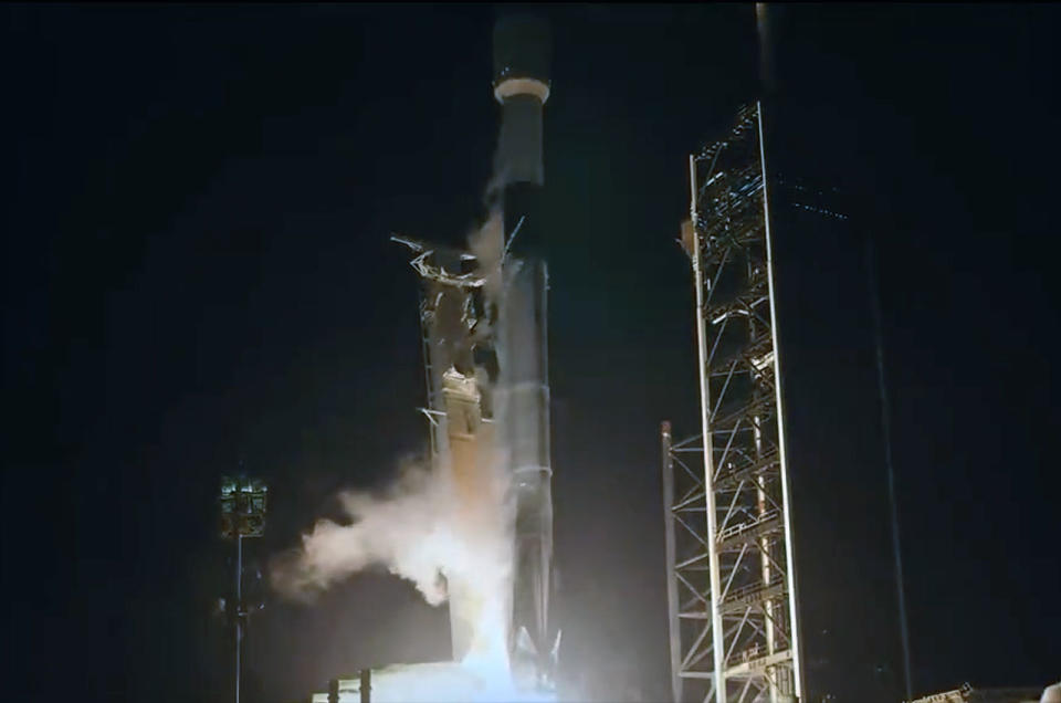 a black-and-white spacex falcon 9 rocket launches into the night sky