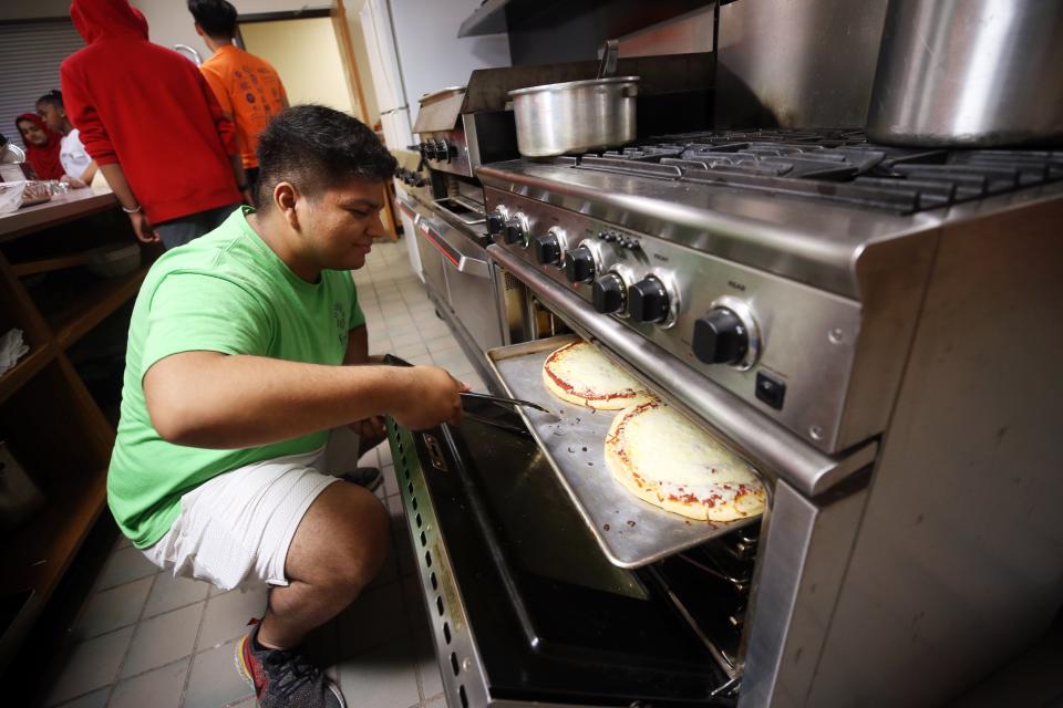 Volunteer Randy Villanueva, a 2021 graduate of Hilliard Bradley, checks on the pizzas during the Festa Free Summer Lunch Camp at Hilliard Church of Christ on July 8.