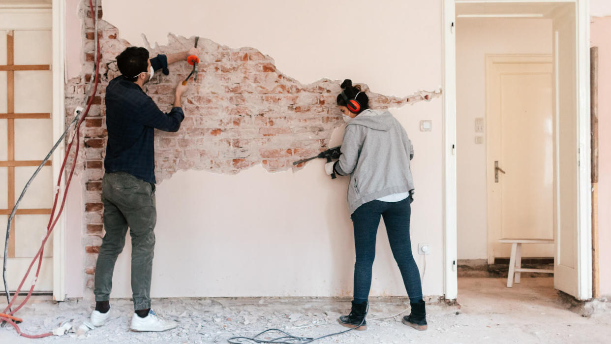 Young couple working on reconstruction of their apartment.