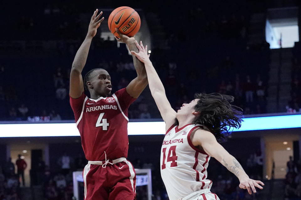 Arkansas guard Davonte Davis (4) shoots over Oklahoma guard Bijan Cortes (14) in the second half of an NCAA college basketball game Saturday, Dec. 11, 2021, in Tulsa, Okla. (AP Photo/Sue Ogrocki)