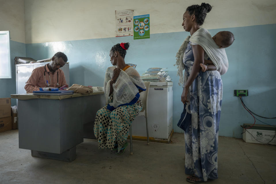 Dr. Tewodros Tefera, surgeon and doctor-turned-refugee, treats Tigrayan refugee women inside the Sudanese Red Crescent (SRC) Clinic, at Hamdeyat Transition Center near the Sudan-Ethiopia border, eastern Sudan, March 17, 2021. (AP Photo/Nariman El-Mofty)