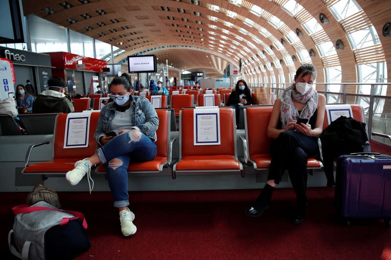 Passengers, wearing protective face masks, wait to board an Air France flight to Mexico City in Terminal 2E at Paris Charles de Gaulle airport in Roissy-en-France during the outbreak of the coronavirus disease (COVID-19) in France